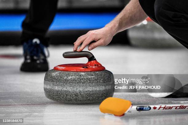 Competitor prepares to curl the stone during the men's bronze medal game of the Beijing 2022 Winter Olympic Games curling competition between Canada...