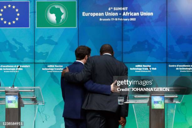 French President Emmanuel Macron embraces Kenya's President Uhuru Kenyatta during a meeting on the second day of a European Union African Union...