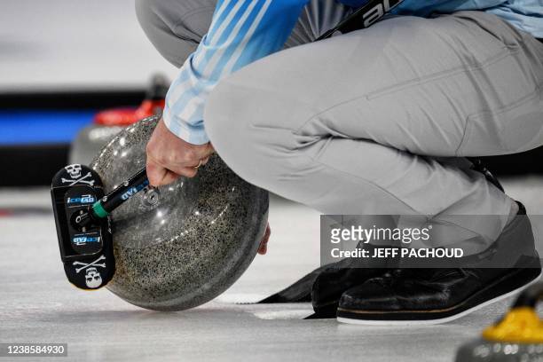 S John Shuster preapares to curl the stone during the men's bronze medal game of the Beijing 2022 Winter Olympic Games curling competition between...