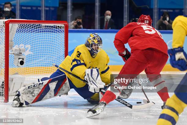 Lars Johansson of Sweden and Anton Slepyshev of Russia battle for the puck at the men's ice hockey playoff semifinal match between ROC and Sweden...