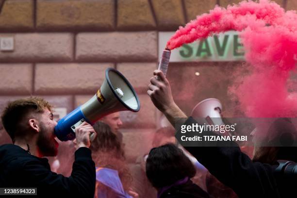 Students hold megaphones and a smoke bomb during a protest organized by students to ask for more safety in their work experience in Rome on February...