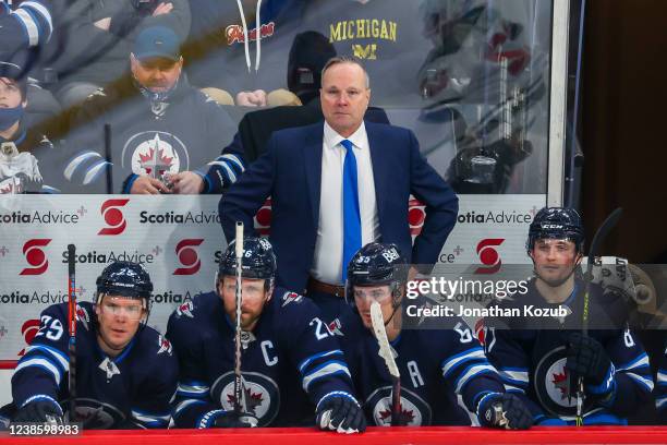 Head coach Dave Lowry of the Winnipeg Jets looks on from the bench behind teammates Paul Stastny, Blake Wheeler, Mark Scheifele, and Kristian Reichel...