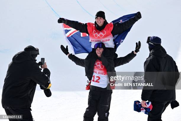 Gold medallist New Zealand's Nico Porteous poses for a photo taken by a team member as he is carried by his brother Miguel Porteous after the...
