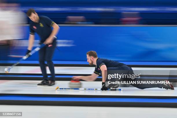 Sweden's Rasmus Wranaa curls the stone during the men's gold medal game of the Beijing 2022 Winter Olympic Games curling competition between Sweden...