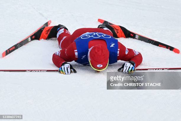 Russia's Alexander Bolshunov reacts after crossing the finish to win Gold in the men's 50km mass start free event, which was shortened to 30km due to...