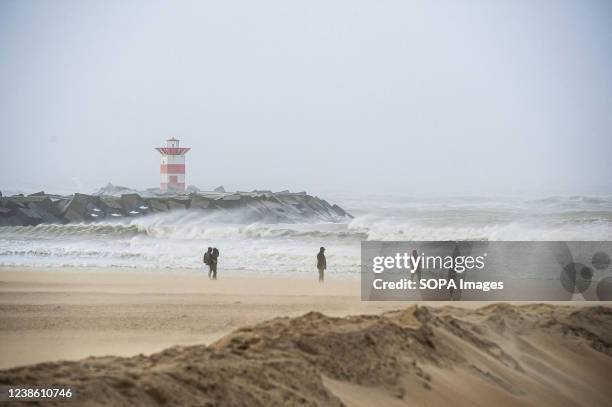 People are seen on the Dutch beach resort of Scheveningen, in The Hague, as Storm Eunice arrives from the UK. Today, the Netherlands was brought to a...