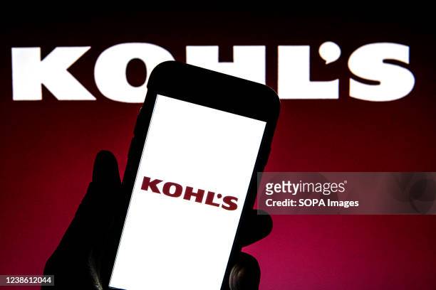 In this photo illustration a Kohl's Corporation logo seen displayed on a smartphone with a Kohl's Corporation logo in the background.