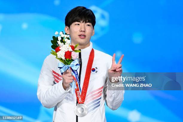 Silver medallist South Korea's Chung Jae-won poses on the podium during the men's speed skating mass start victory ceremony of the Beijing 2022...