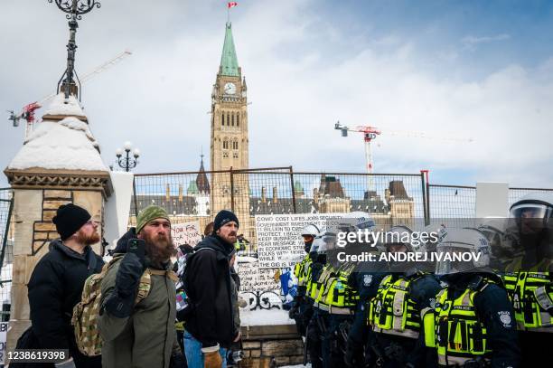 Demonstrators continue their protest in front of Parliament Hill as police deploy to remove them on February 19 in Ottawa, Canada. - Police in Canada...