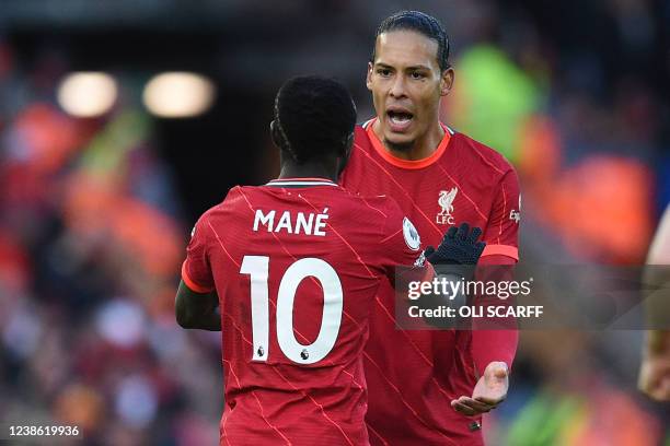 Liverpool's Senegalese striker Sadio Mane celebrates with Liverpool's Dutch defender Virgil van Dijk after scoring their first goal during the...