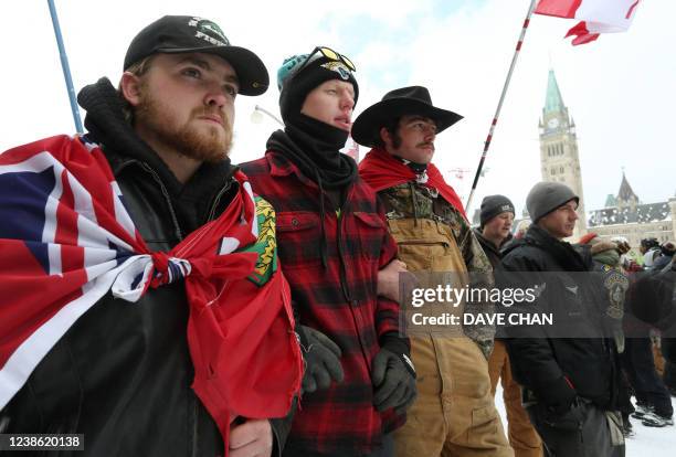 Protesters lock arms as a police line pushes forward on February 19, 2022 in Ottawa, Canada. - Police in Canada deployed to dislodge the final...