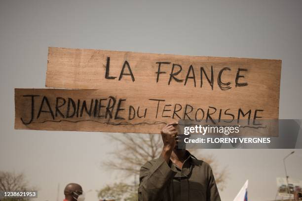 Protester holds a placard reading "France, gardener of terrorism" during a demonstration organised by the pan-Africanst platform Yerewolo to...