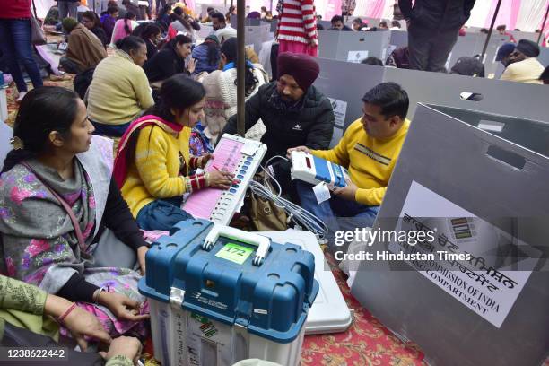 Polling officials examine Electronic Voting Machines and other election materials before leaving for their respective polling booths on the eve of...