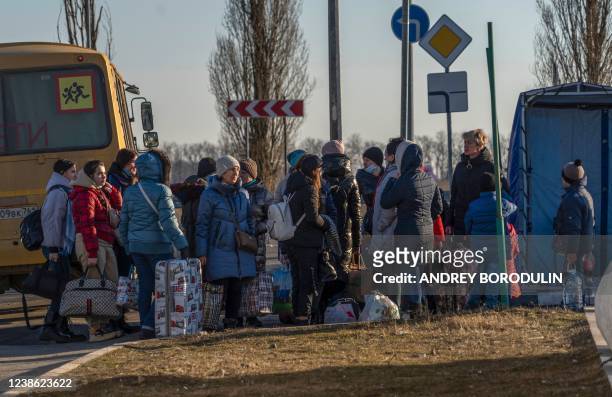 People evacuated from the self-proclaimed Donetsk People's Republic walk toward the Russian Emergency Ministry camp in the village of...