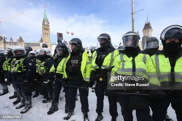 Protesters from the "Freedom Convoy" in Ottawa are moved from Wellington Street in front of Parliament Hill by police officers after blockading the...