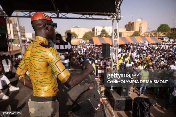 Man with military body painting stand on the stage of a meeting to show support to the military, in Ouagadougou on February 19, 2022.