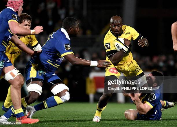 La Rochelle's South African centre Raymond Rhule is tackled by Clermont's French hooker Etienne Fourcade during the French Top14 rugby union match...