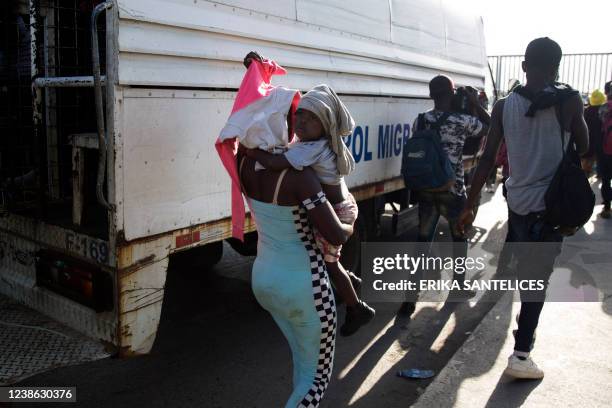 Haitian citizens deported in the Dominican Republic by immigration control agencies arrive at the gate on the border that divides the Dominican...