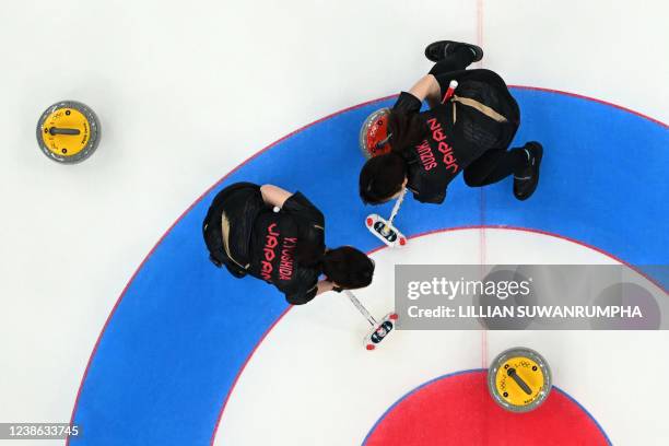 This overview shows Japan's Yurika Yoshida and Japan's Yumi Suzuki sweeping during the women's gold medal game of the Beijing 2022 Winter Olympic...