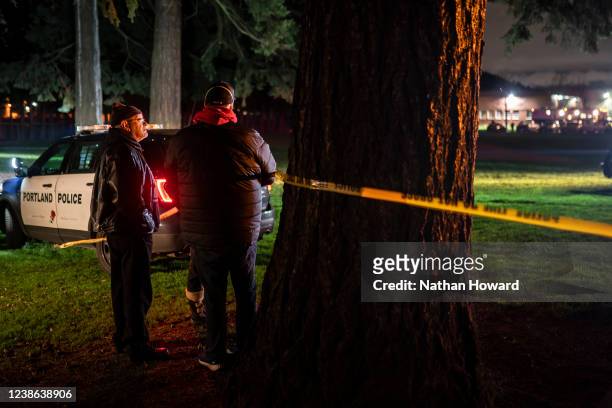 Neighbors watch as Portland police investigate a shooting that took place during a protest for Amir Locke, which officials said left one dead and...