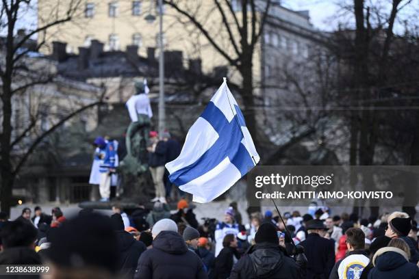 Finnish fans celebrate with their national flag early morning in downtown Helsinki, on February 20 as Finland won the Beijing 2022 Winter Olympic...