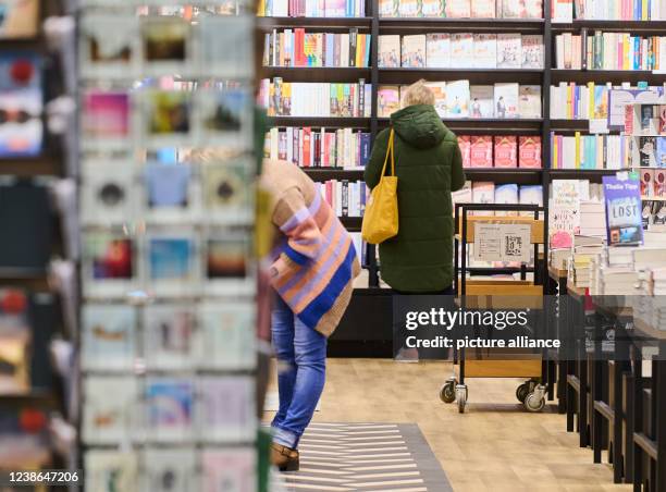 February 2022, Berlin: In the Schönhauser Allee Arcaden, a woman stands in the bookstore. Today is open Sunday in Berlin. The 2G and 3G regulations...