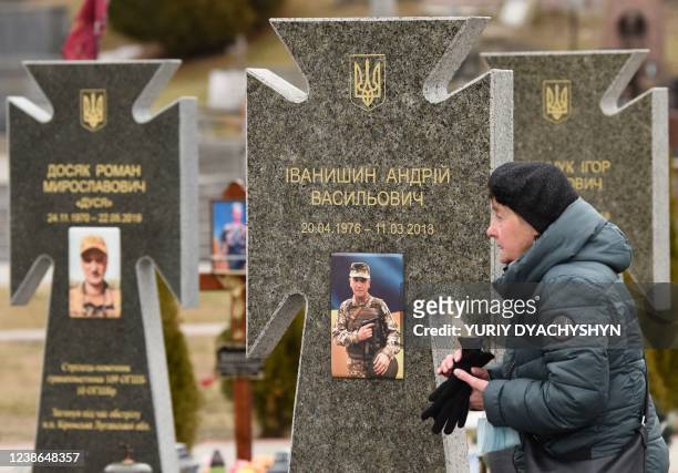Woman walks next to graves of Ukrainian soldiers during commemoration ceremony at the Lychakiv cemetery in Lviv western Ukraine, on February 20, 2022.