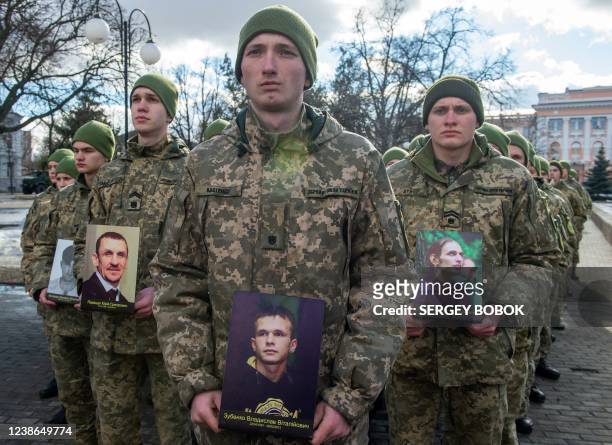 Ukrainian military cadets hold portraits of fallen Maidan activists, during a memorial event for the "Heroes of the Heavenly Hundred", referring to...