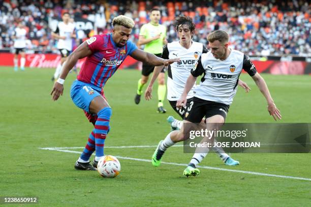 Barcelona's Spanish forward Adama Traore vies with Valencia's Spanish defender Toni Lato during the Spanish league football match between Valencia CF...