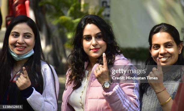 Voters pose with the ink marked fingers after casting their votes at a polling station during Punjab state assembly elections on February 20, 2022 in...