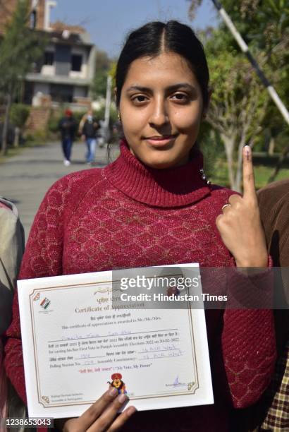 First time voter Amrita Kaur Sandhu show her ink marked finger after casting her vote at a polling station during Punjab state assembly election on...