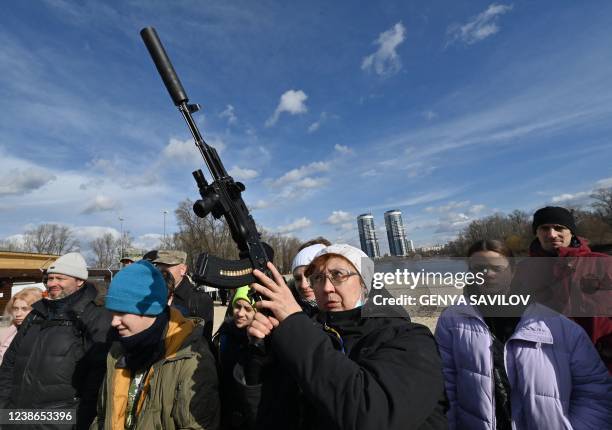 Residents attend an open training organised for civilians by war veterans and volunteers who teach the basic weapons handling and first aid on one of...