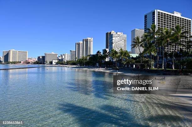 Dog frolicks in the water on Waikiki Beach in Honolulu, Hawaii, early February 20, 2022.