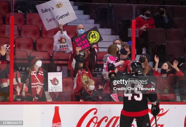 Parker Kelly of the Ottawa Senators throws a puck to fans during warmups prior to a game against the New York Rangers at Canadian Tire Centre on...