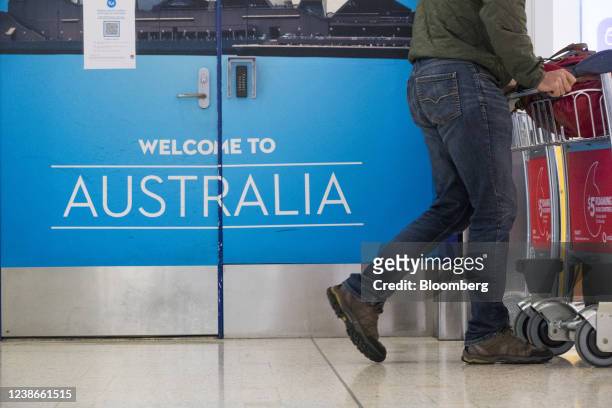 Traveler walks past a 'welcome to Australia' sign at the arrival hall at the international terminal of Sydney Airport in Sydney, Australia, on...