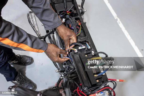 Technician from Opibus assembles an electric motorcycle at their warehouse in Nairobi on February 15, 2022. - This Kenyan-Swedish company was founded...