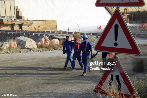 Construction team walk as Grand Ethiopian Renaissance Dam is seen behind them in Benishangul-Gumuz, Ethiopia on February 19, 2022. Ethiopia built the...