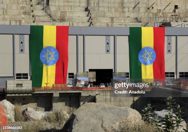 View of Grand Ethiopian Renaissance Dam and Ethiopian flags on a building near a massive hydropower plant on the River Nile that neighbors Sudan and...