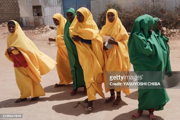 Female students walk along a street in Baidoa, Somalia, on February 14, 2022.