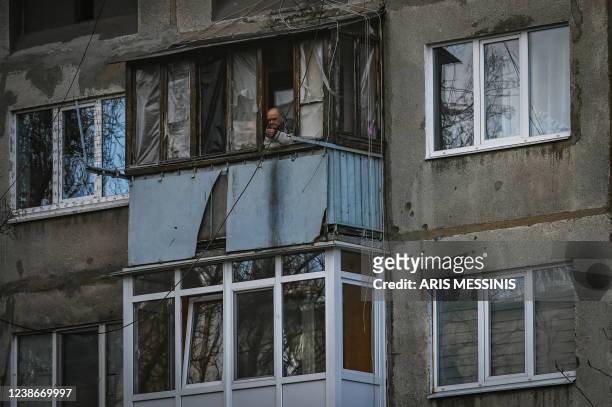 An elderly man stands at the window of his house in the city of Avdiivka, eastern Ukraine, on February 21, 2022. - Ukraine on Monday firmly denied...