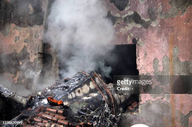 Firefighters put out a blaze at the crash site of a fighter jet in a residential area of the northwestern city of Tabriz on February 21, 2022. - An...