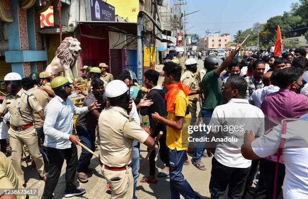 Police personnel try to stop rioters from entering a Muslim dominated area during a procession as tension spreads in Shivamogga town over the murder...