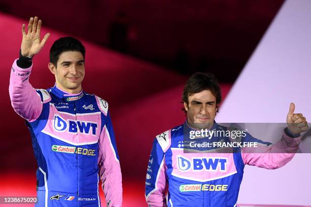 Alpine F1 team's drivers French Esteban Ocon and Spanish Fernando Alonso gesture during the unveiling of Alpine F1 team's A522 new racing car for the...