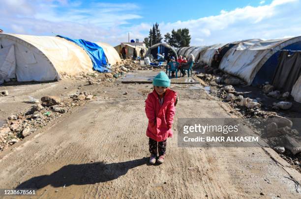 An internally displaced Syrian child is pictured standing between tents in a camp, before being transported to a new housing complex in the...