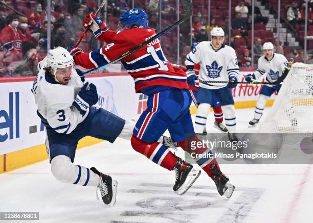 Nick Suzuki of the Montreal Canadiens delivers a hit on Justin Holl of the Toronto Maple Leafs during the second period at Centre Bell on February...