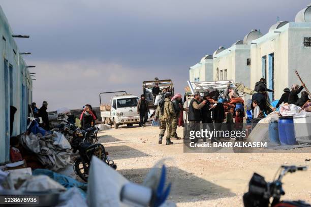 Internally displaced Syrians unload their belongings from trucks upon arrival at a new housing complex in the opposition-held area of Bizaah, east of...