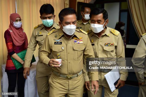 Narathiwat governor Sanan Pongaksorn holds a collection cup containing his urine sample as part of a government drug testing programme at City Hall...