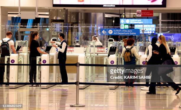 Passengers use the smart passport gates at Dubai International Airport on February 21, 2022. - Passenger traffic at Dubai international airport, the...
