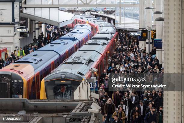 Commuters, some continuing to wear face masks, arrive at Waterloo station during morning rush hour as all of England's remaining Covid restrictions...