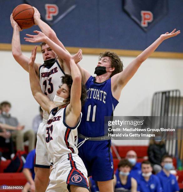 February 22: Pembroke Tom Consideline and Noah Petillo rebound against Scituate Brady Burns during the second quarter of the boys high school...